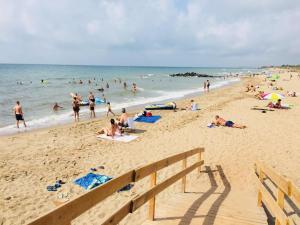 un grupo de personas en una playa con el océano en Camping le Roucan West, en Vias