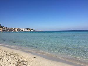 a beach with the ocean and buildings in the background at Domus Orestea Luxury Suites in Palermo