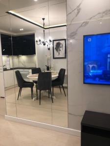 a dining room with a table and chairs and a tv at APARTAMENT BLIŻEJ MORZA Sorrento in Kołobrzeg