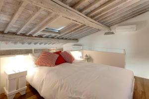 a bedroom with a large white bed with red pillows at Mamo Florence - Mattonaia Apartment in Florence
