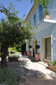 a white house with potted plants and a tree at Guerrini Hotel in Castiglioncello
