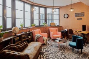a living room with a couch and chairs and windows at Hotel Memories OldTown in Budapest
