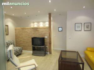 sala de estar con sofá y TV en apartamento el mirador en Ezcaray