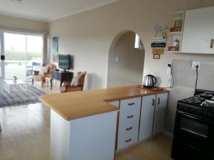 a kitchen with white cabinets and a counter top at Top Deck in Struisbaai