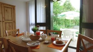 mesa de comedor con plato de comida y sombrilla en VVF Cantal Champs-sur-Tarentaine, en Champs Sur Tarentaine
