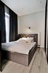 a bedroom with a large bed with white sheets at City Center loft in Kaunas
