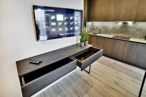 a kitchen with a large tv on the wall at City Center loft in Kaunas