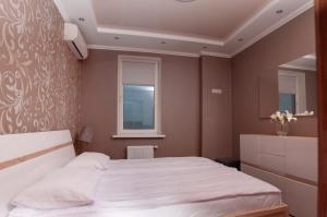 een slaapkamer met een wit bed en een raam bij Apartment on Pozhyaki in Kiev