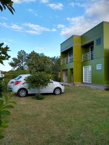 un coche blanco estacionado frente a una casa en Pousada San Jose en Pântano Grande