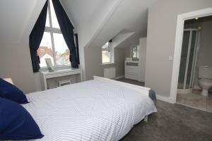 a bedroom with a white bed and a window at Strand House 2 in Portstewart