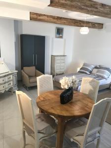 a room with a table and chairs and a bed at Chambre Familiale du Couvent in Narbonne