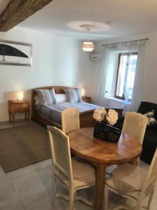 1 dormitorio con 1 cama, mesa y sillas en Chambre Familiale du Couvent, en Narbona