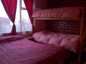 1 dormitorio con 2 literas y ventana en Hostel Melinda, en Puerto Natales