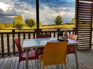 a table and chairs on a deck with a view at VVF Vienne Poitou in La Bussière