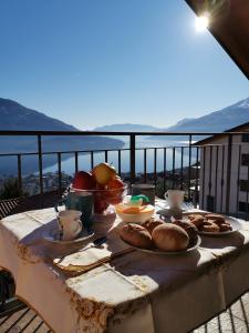 une table avec des assiettes de nourriture sur un balcon dans l'établissement Casa Sole, à Vercana