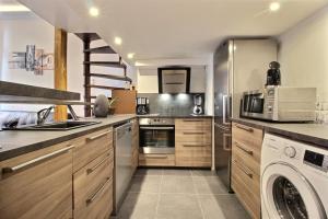 a large kitchen with a washer and dryer in it at TOULOUSE DUPLEX PLACE DU CAPITOLE in Toulouse