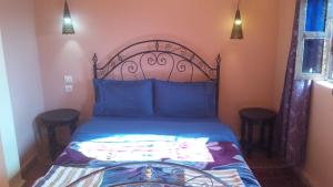 - une chambre avec un lit doté de draps bleus et d'oreillers bleus dans l'établissement Riad Tifor, à Marrakech