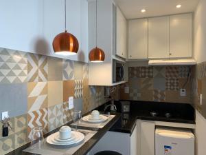 uma cozinha com armários brancos e pratos no balcão em The Best Apartment in Copacabana - Quarto e Sala no Rio de Janeiro