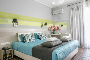 1 dormitorio con 1 cama con sábanas y almohadas azules en Myrto Hotel, en Mati