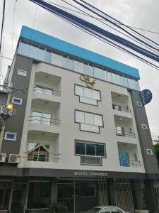 a white building with a blue roof at Hotel Santa Fe in Manta