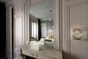 Hotel de Paris في ليون: غرفة مع غرفة نوم مع سرير ومدفأة