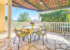 een tafel en stoelen op een patio met een hek bij Apartmani Marin in Medulin