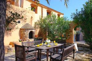 a wooden table with chairs and a tableasteryasteryasteryasteryasteryasteryasteryastery at Finca Can Jordi in Felanitx