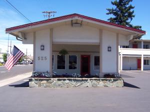 ein Gebäude mit amerikanischer Flagge davor in der Unterkunft Red Carpet Inn Medford in Medford