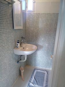 a small bathroom with a sink and a shower at Atrium House - Boletsis in Anapaftíria