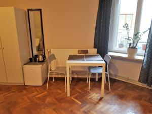 uma mesa e cadeiras num quarto com uma janela em Libroom na Cracóvia