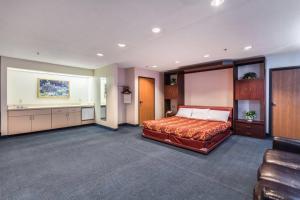 Quality Express Inn & Suites في Mineralwells: غرفة نوم كبيرة بها سرير ومغسلة