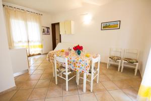 a dining room with a table with flowers on it at Iris Houses in San Teodoro