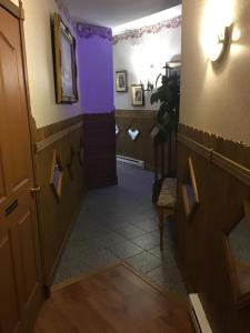un corridoio con pareti viola e una porta di Auberge La Cote d'Or a Petite-Rivière-Saint-François