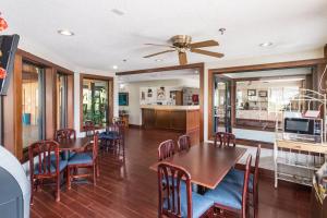 Quality Express Inn & Suites في Mineralwells: غرفة طعام مع طاولات وكراسي ومروحة سقف