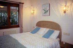 a bedroom with a bed with two blue pillows at Las Bellotas in Moraira +26 photos