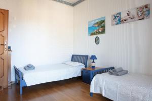Zimmer mit 2 Betten, einem Tisch und einer Uhr in der Unterkunft Appartamento Tina in Lido di Camaiore