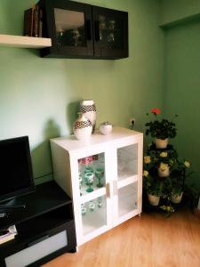 a white cabinet with vases on it in a room with plants at Apartment in Valencia in Valencia