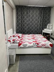 una camera con un letto con una trapunta rossa e bianca. di Centrum DBL-room Dominika a Bardejov