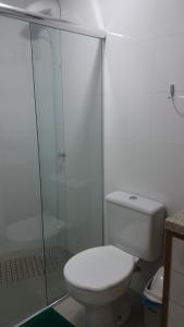 a white bathroom with a toilet and a shower at Apartamento Ed. London in Piratuba