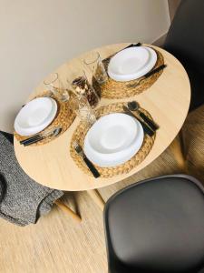 a round wooden table with plates and glasses on it at Sweet home30 in Vilnius
