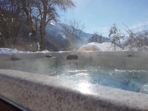 un bain à remous avec de la neige au-dessus dans l'établissement Chalet Solneige, à Vaujany