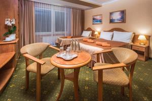 シフィノウイシチェにあるHotel Polaris IIIのベッド、テーブル、椅子が備わるホテルルームです。