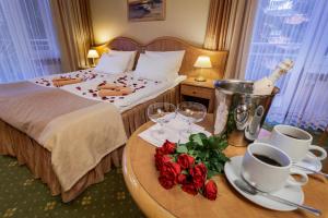 a hotel room with a bed and a table with roses at Hotel Polaris III in Świnoujście