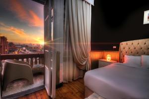 a bedroom with a bed and a view of a city at Tahrir Plaza Suites - Museum View in Cairo