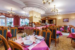 a dining room with tables and chairs and pink tablecloths at Hotel Polaris III in Świnoujście +57 photos