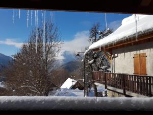 ヴォジャニーにあるChalet Solneigeの雪に覆われた家で、景色を望むバルコニーが付いています。