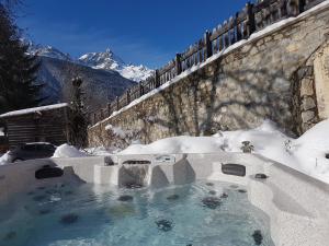 una bañera de hidromasaje cubierta de nieve junto a una valla en Chalet Solneige en Vaujany