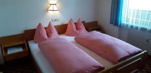 a bed with pink pillows on it in a room at Haus Fichtenblick in Auffach