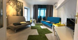 ブカレストにあるGreen Apartmentのリビングルーム(青いソファ、緑のラグ付)