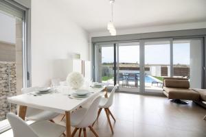 a white dining room with a white table and chairs at Villa Malibu 3021 in Vistabella